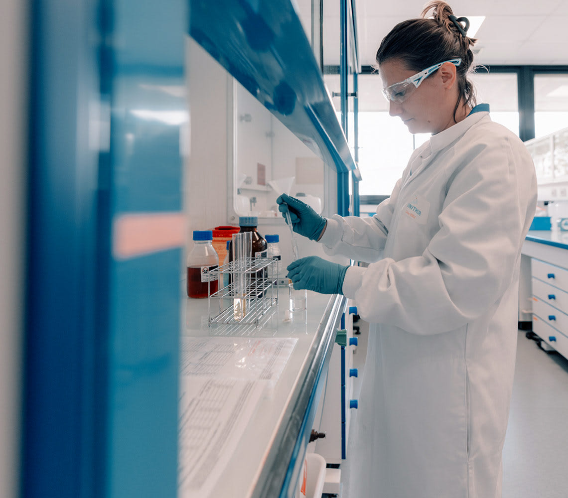 A woman in a lab coat diligently conducts research, embodying innovation in the evolving pharmaceutical sector.